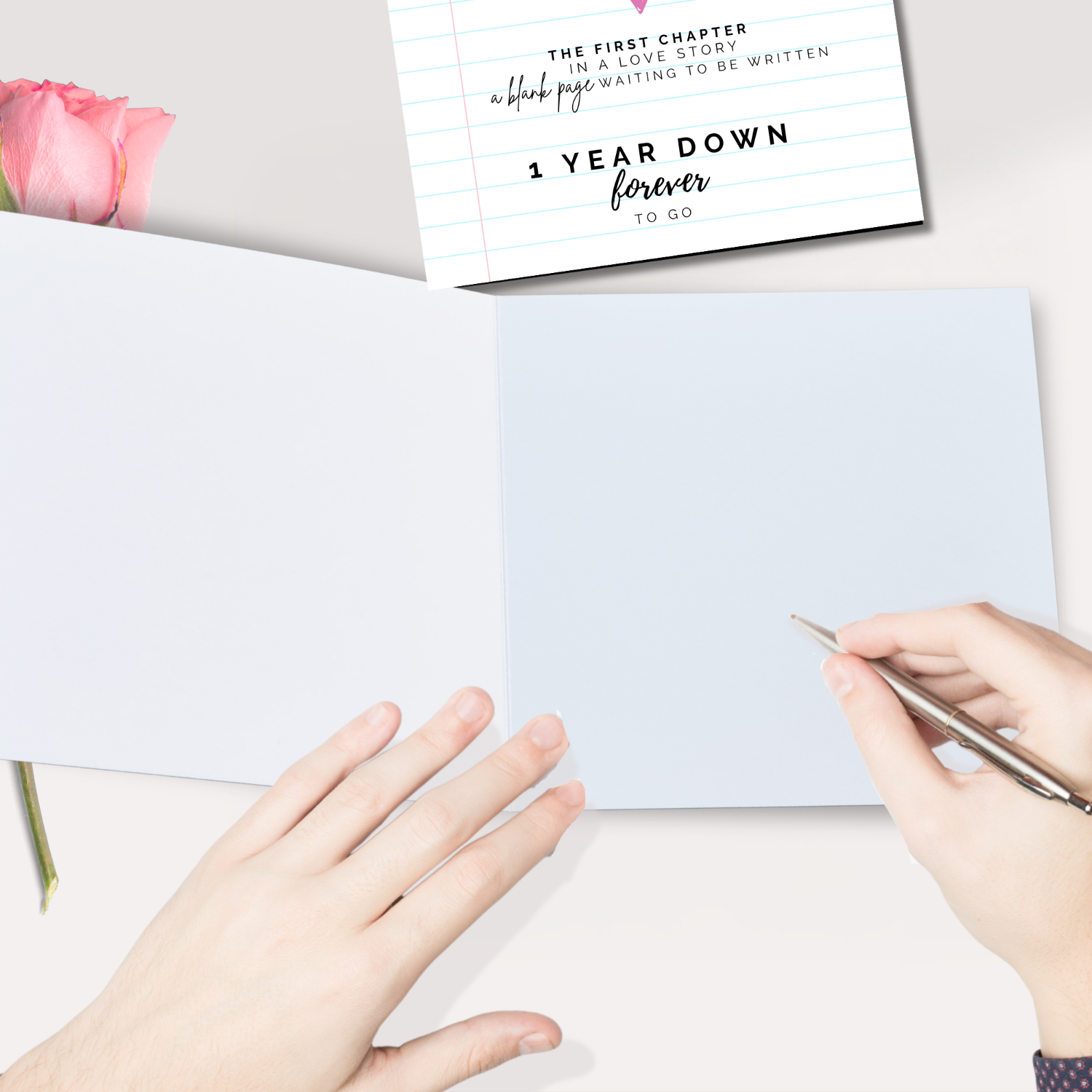 1st First Anniversary Card - Person writing on a card with a pink flower and '1 Year Down Forever to Go' card in the background.
