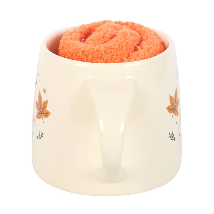 Ceramic container with a floral design holding a coral-colored sponge on a white background