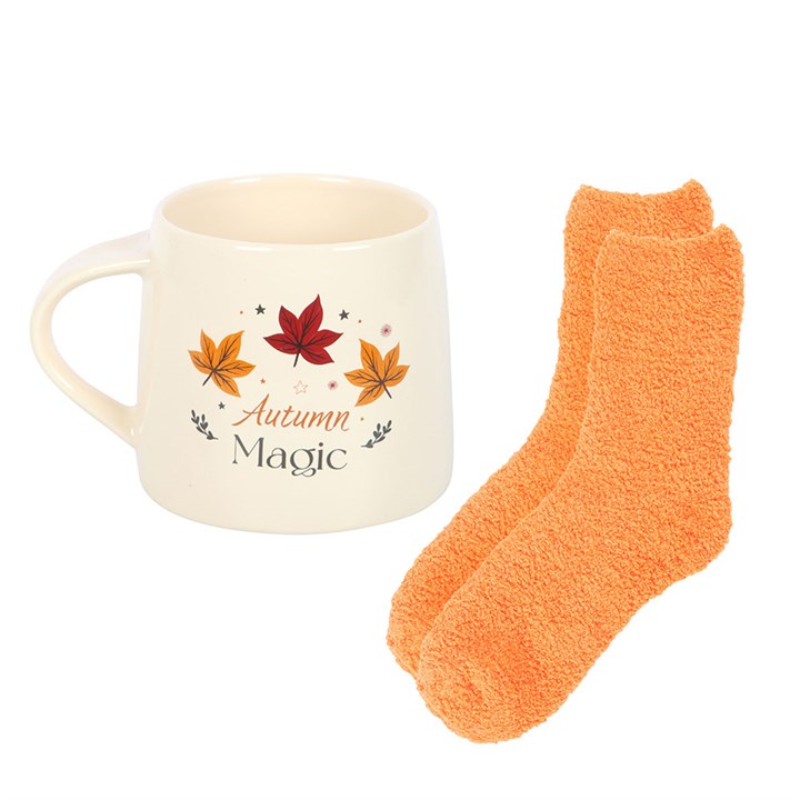 Mug with autumn-themed design and orange socks on a white background