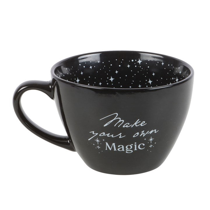 Black mug with star pattern and 'Make your own magic' text on a white background