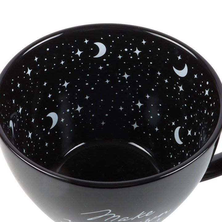 Black mug with star and moon pattern on a white background