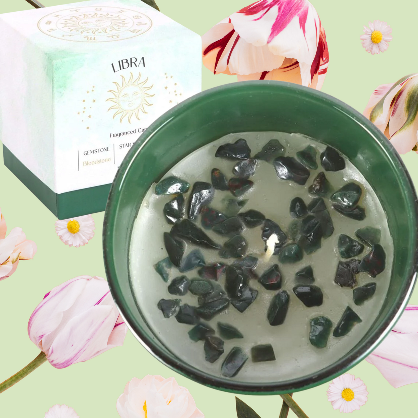 Candle with stones in a green container on a floral background with Libra box.