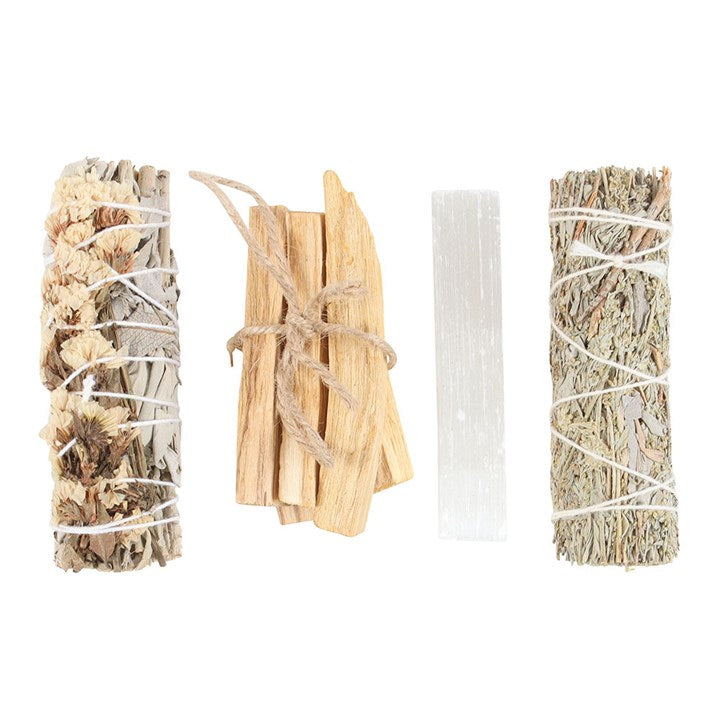 Set of three palo santo sticks, 2 sage smudge sticks and a white selenite wand crystal in a box as a energy cleanse kit on a white background