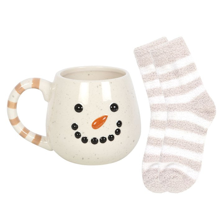 Snowman-themed mug with a face and a striped sock on a white background