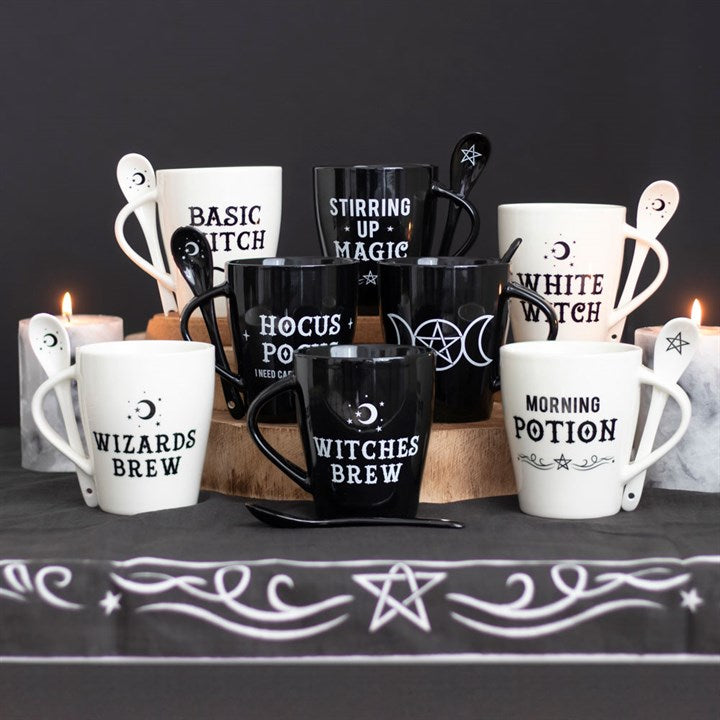 Collection of Halloween-themed mugs and kitchen utensils on a dark surface with a black background.
