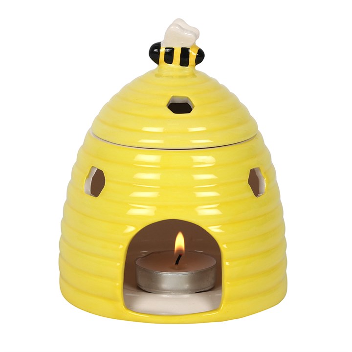 Yellow ceramic bee oil burner with a tealight candle inside on a white background for oil fragrance