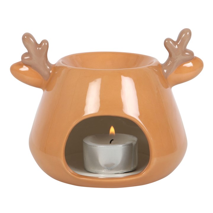 Ceramic oil burner with reindeer antlers holding a lit candle on a white background