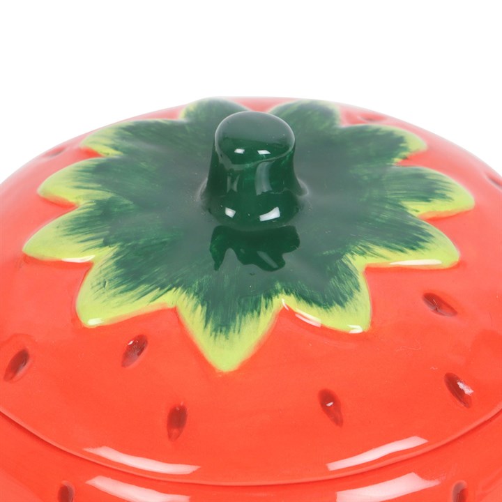 Strawberry wax warmer with a green lid on a white background