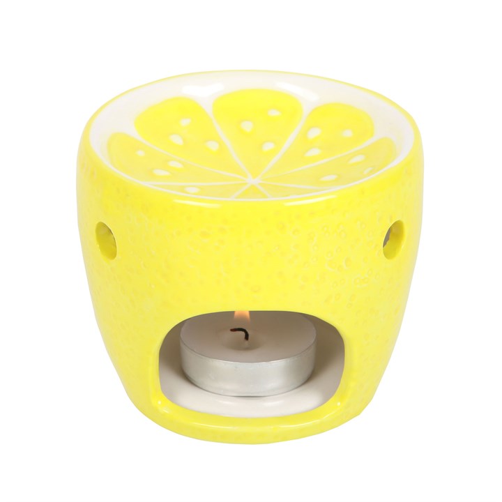 Yellow lemon-shaped tealight holder wax warmer oil burner with a lit tealight on a white background