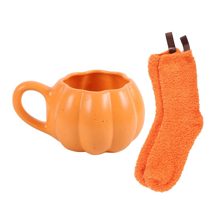 Pumpkin-shaped mug and orange socks on a white background