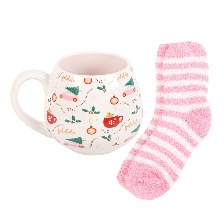 Mug with Christmas design and pink striped sock on a white background