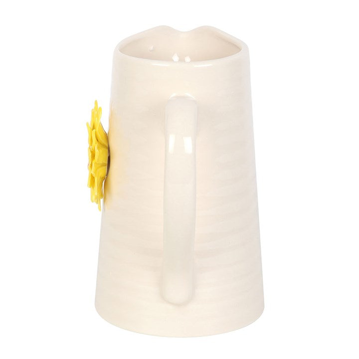 White jug vase with a yellow flower on a white background