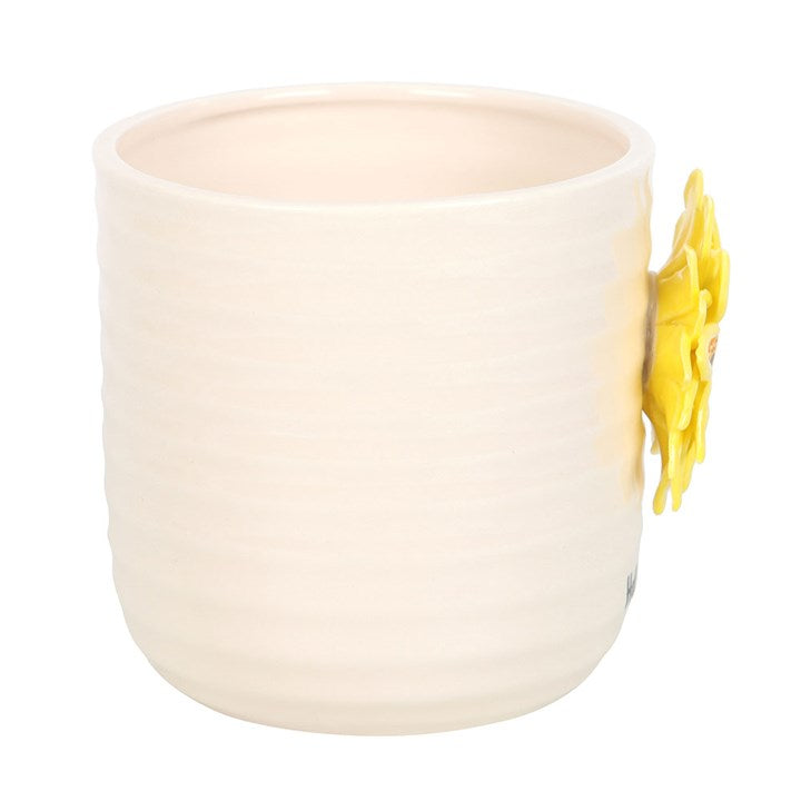 White ceramic vase planter with a yellow flower design on a white background