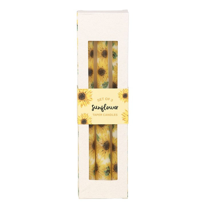 Set of sunflower-themed candles in a decorative box on a white background