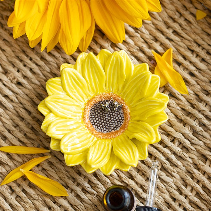 Yellow sunflower-shaped object with a beehive design on a textured surface