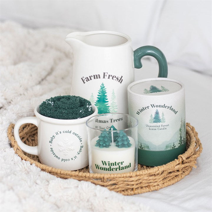 Set of 'Farm Fresh' and 'Winter Wonderland' themed products including a pitcher, mugs, and candles on a woven tray.