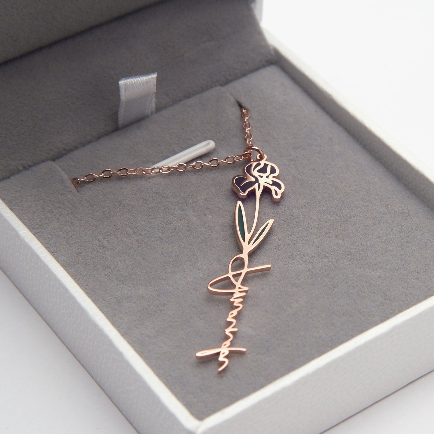 Rose gold necklace with floral design in a gray jewelry box