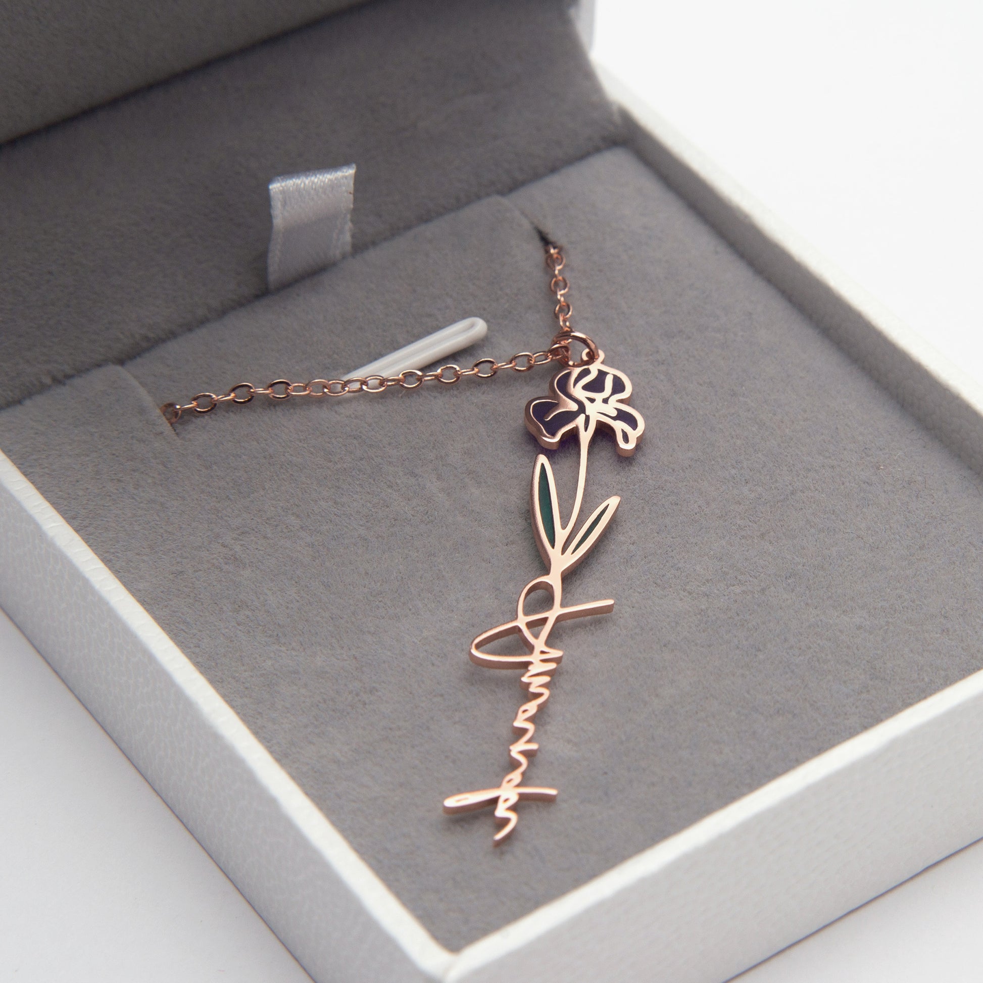 Rose gold necklace with floral design in a gray jewelry box