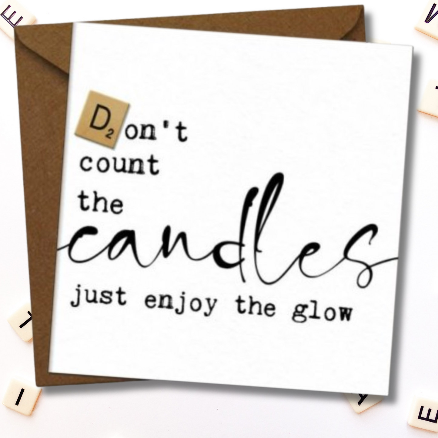 Card with 'Don't count the candles just enjoy the glow' text on a white background with a brown envelope.