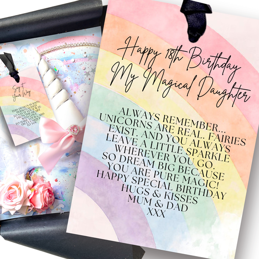 A close-up of a pastel watercolor 18th birthday card with black script and block text reading 'Happy 18th Birthday My Magical Daughter' and a poem about unicorns and fairies, shown next to a matching rolled card on a dark surface.