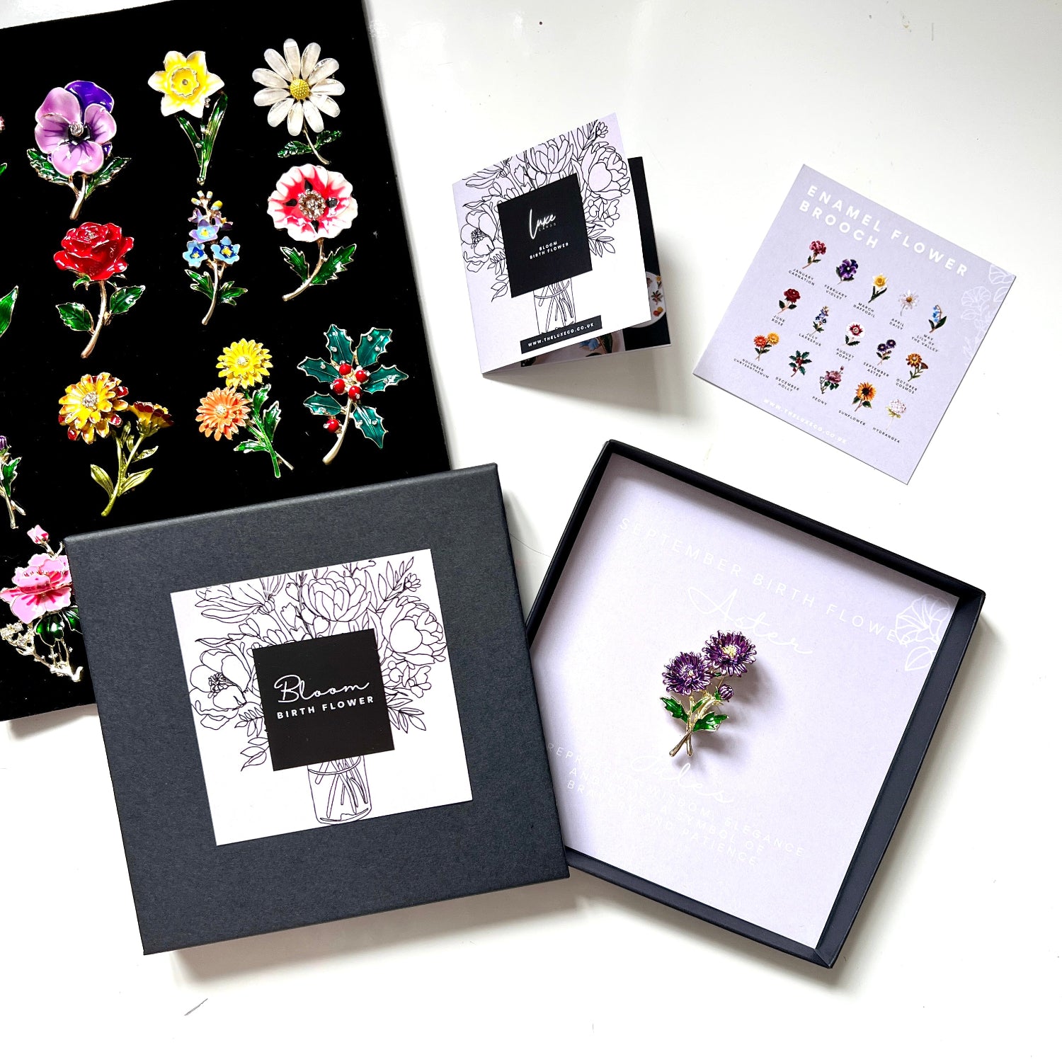 A floral jewellry gift set from Luxe Gifts, featuring a enamel purple flower brooch in a black presentation box to celebrate each birth flower for each month