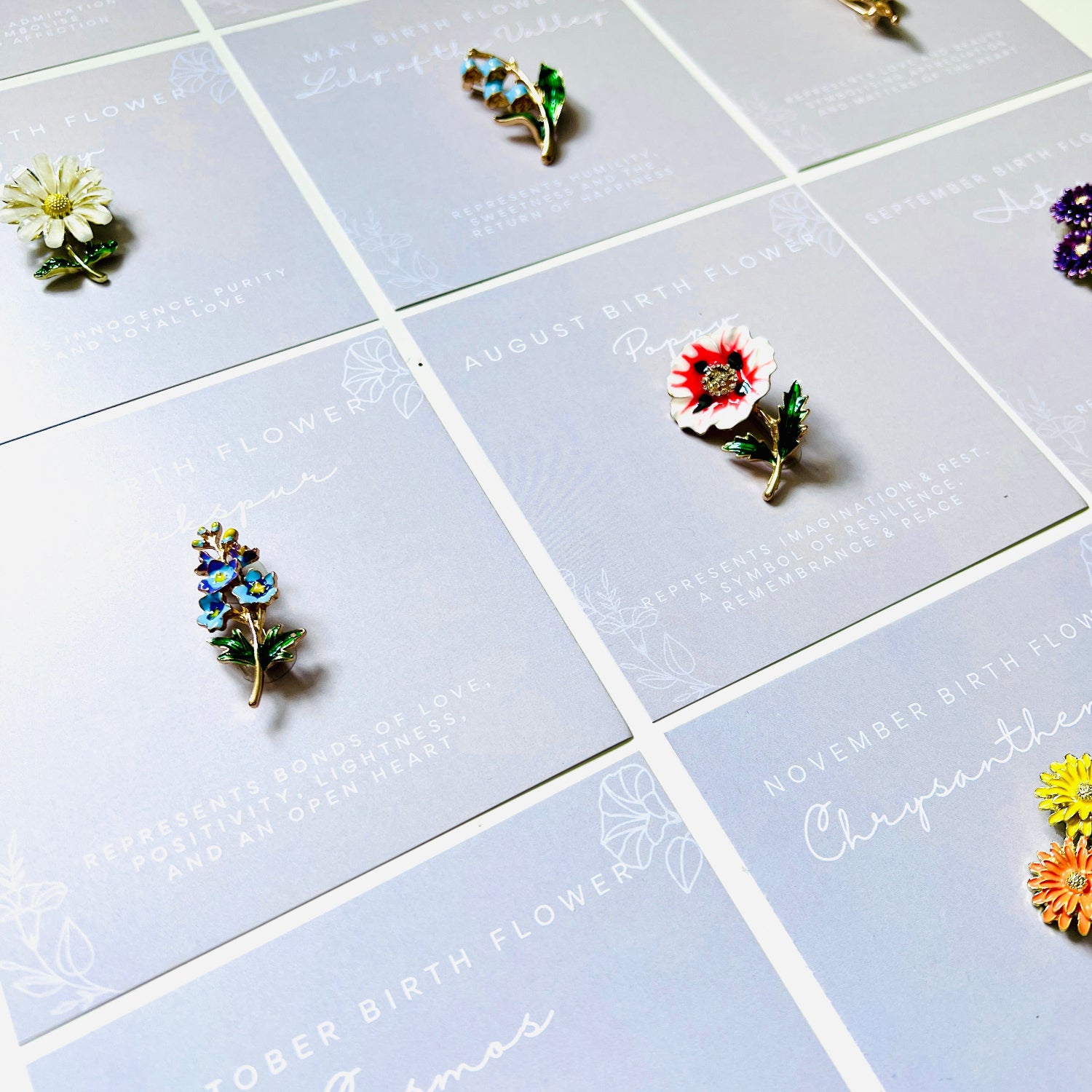 Floral birth flower enamel brooch in different months birthflowers. A gift for each month. The brooches include white, red, blue, yellow, purple, and green floral designs and come gift boxed with characteristics of each months flower.