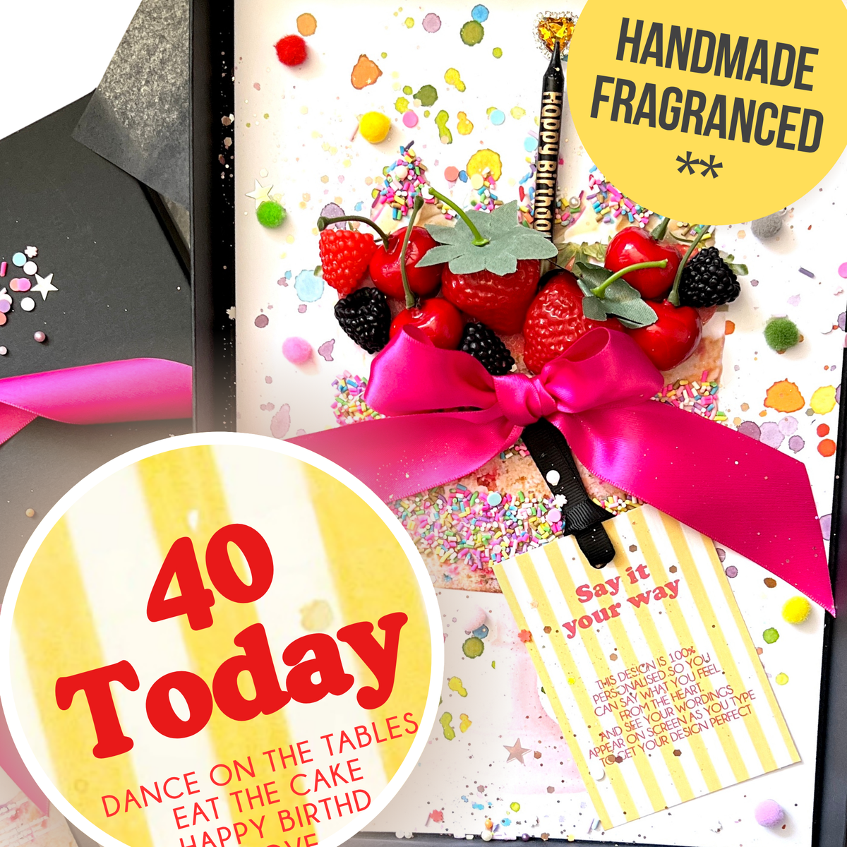 A handmade 40th birthday fragrance gift and card in one featuring a bouquet of strawberries, cherries, and blackberries tied with a bright pink ribbon, a black 'Happy Birthday' candle and a yellow striped card that is personalised
