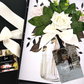 Luxury Personalised Photo Wedding Congratulations Card Floral arrangement with white roses and green leaves, a card, and a box on a white background.