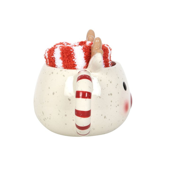 Ceramic mug shaped like a reindeer with a red and white striped hat and candy cane handle on a white background.