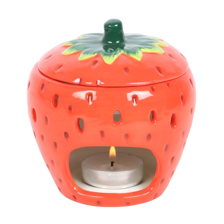 Strawberry ceramic oil burner with a lit candle inside on a white background
