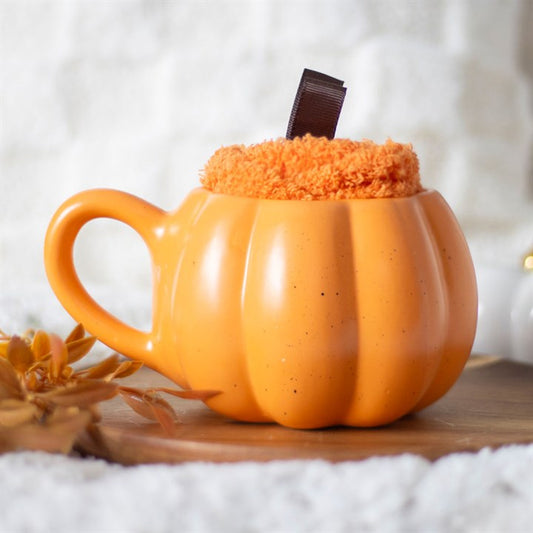 Pumpkin-shaped mug with a handle on a wooden surface