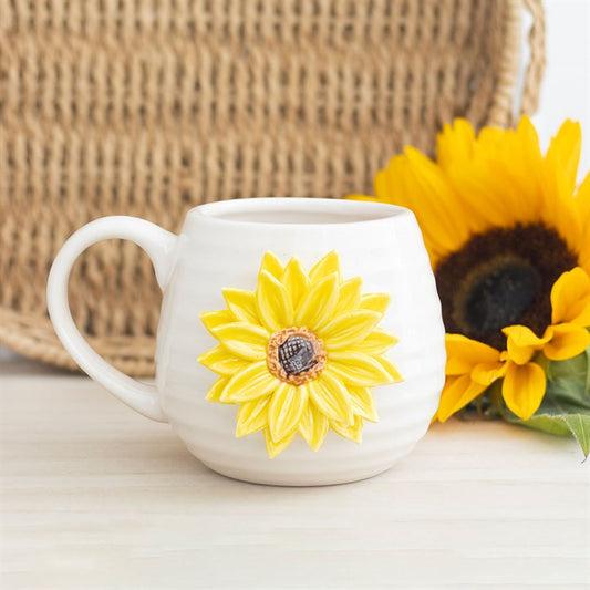 White mug with a yellow sunflower design on a light background