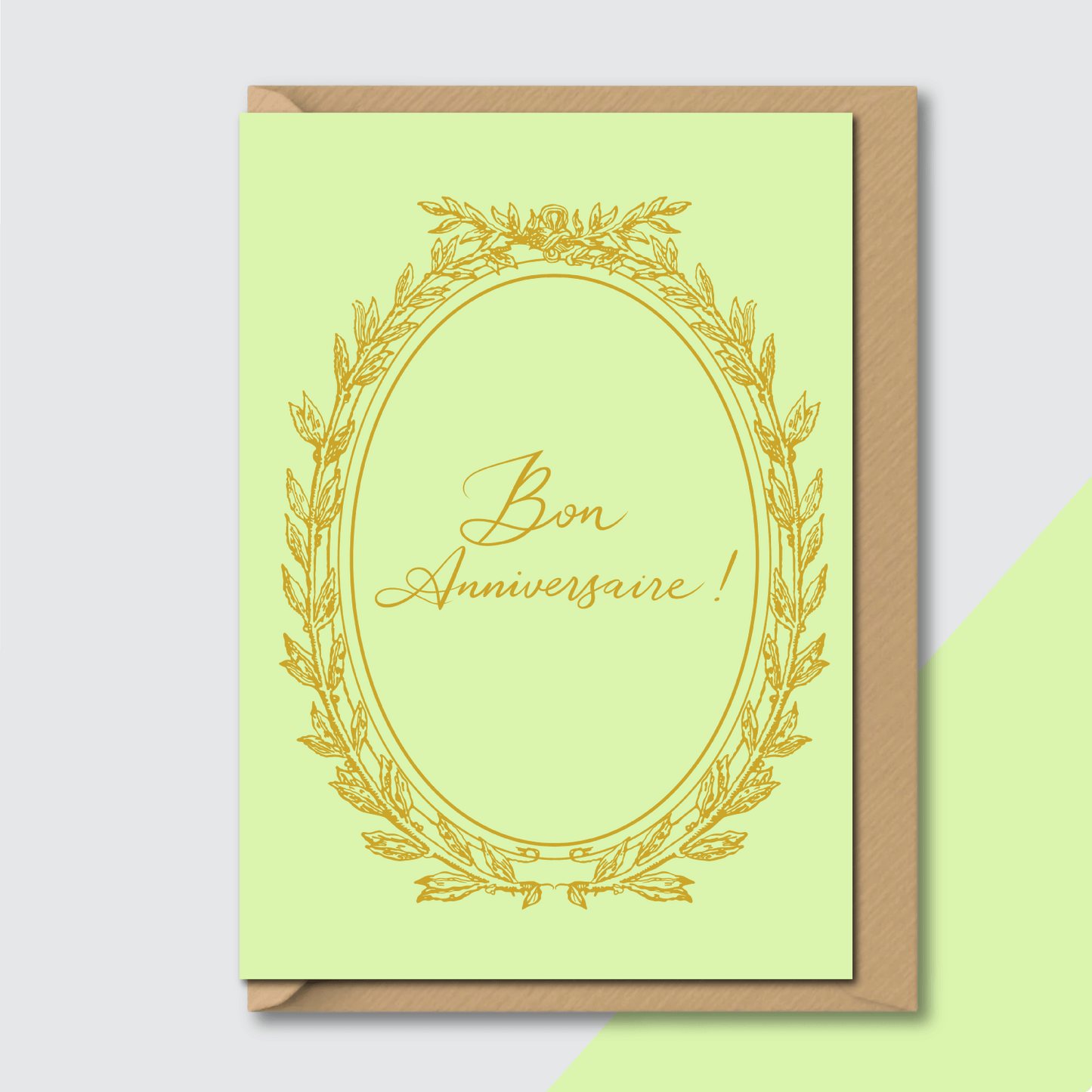 french birthday card bon anniversaire pastel green gold vintage style flat lay on contrasting background with envelope