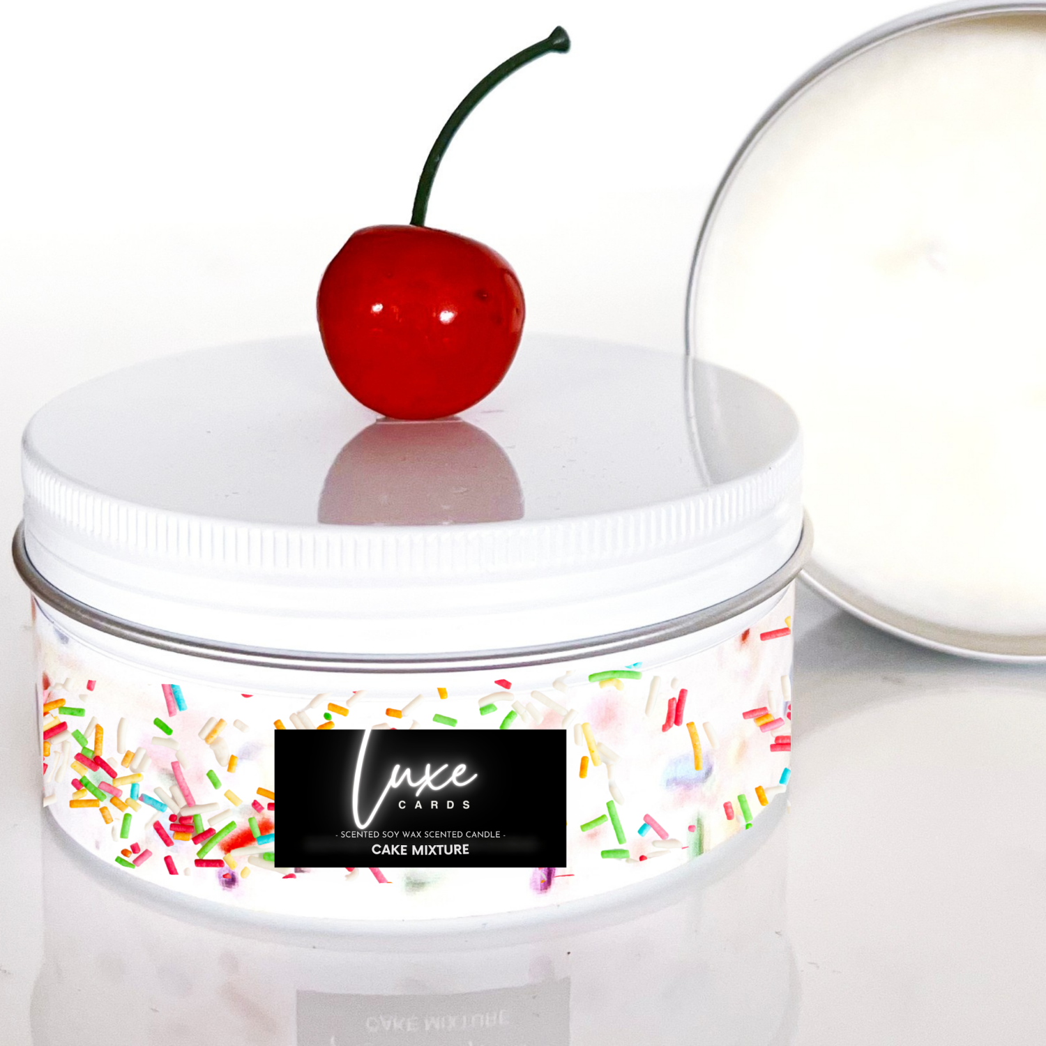 Luxury Birthday Cake Scented Candle tin with a cherry on top and 'Luxe Candles' 